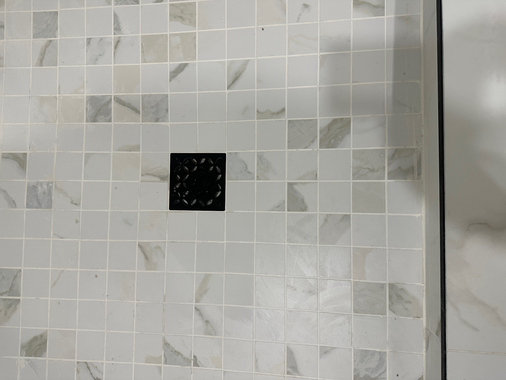 Marble mosaic shower floor with decorative drain