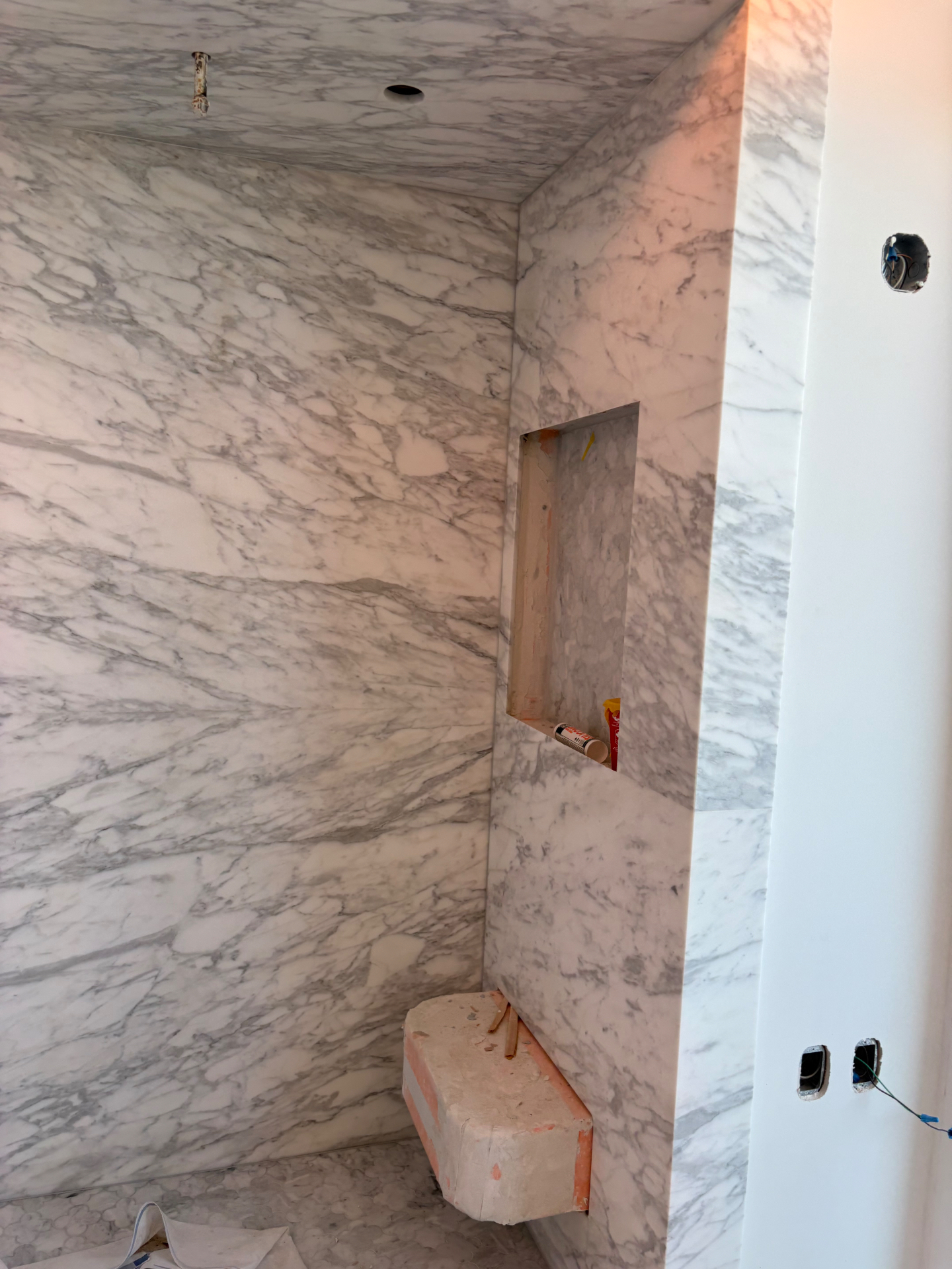 Carrara marble shower walls with custom niche